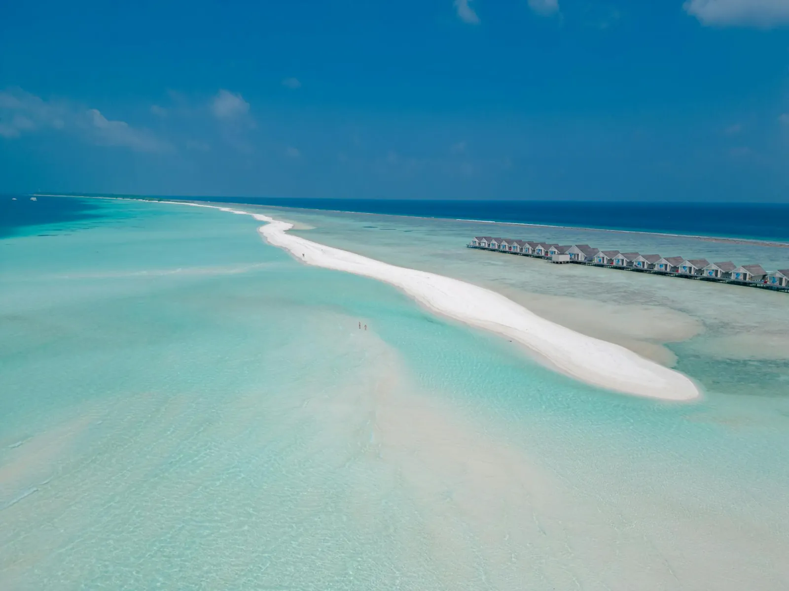 A white sandbank curving through the turquoise lagoon at Dhigurah